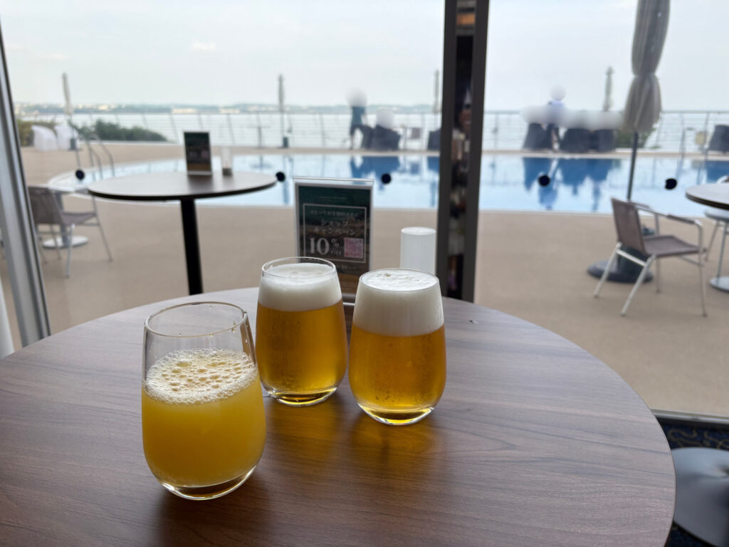 イブニングソーシャルのビールとプールサイドの海ビュー（顔ぼかし加工済み）