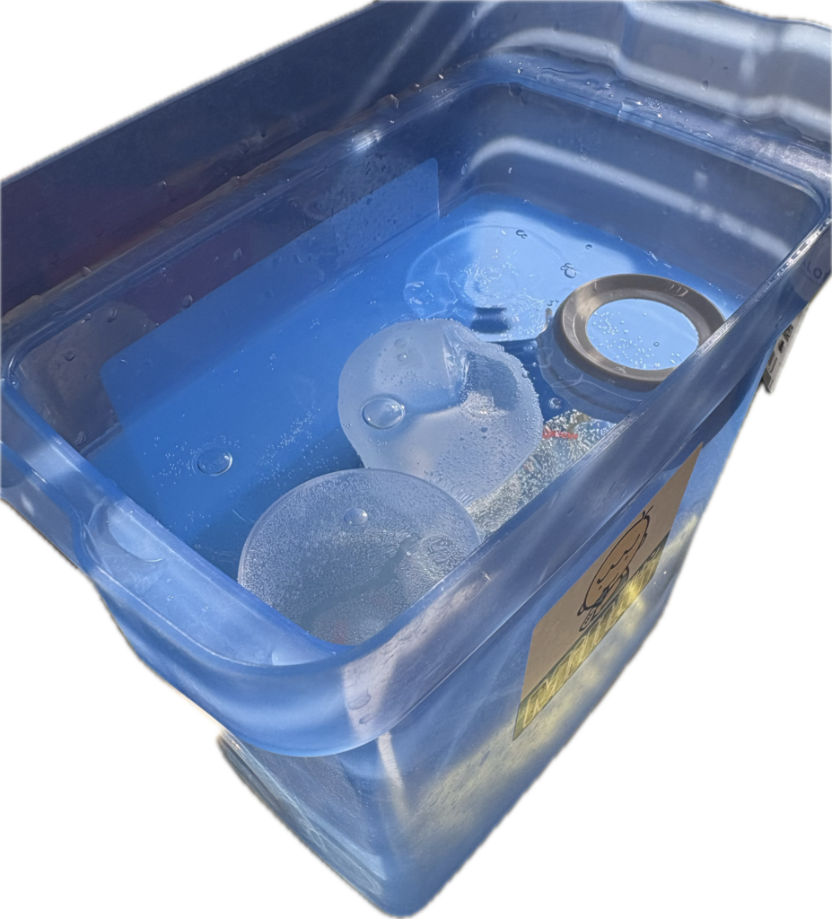 ミルトン専用容器の中に横向きに入れた哺乳瓶とニップル