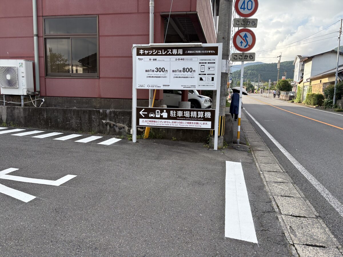 湯布院のコインパーキング料金看板（平日1日300円・土日祝800円）