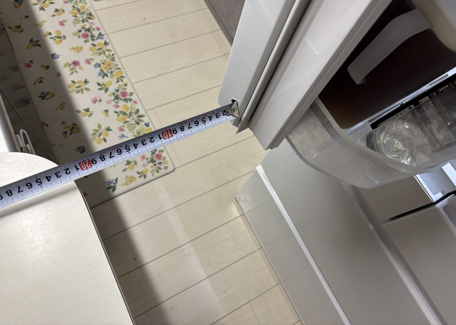 上の両開き扉を開いた状態でカウンターまでのすき間を測っているところ